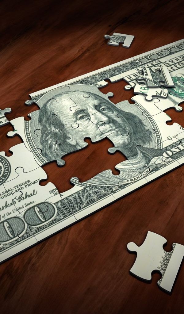 Пазл из купюры сто долларов на столе 