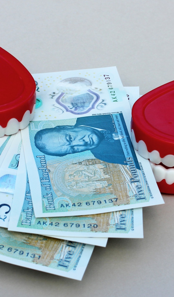 Два держателя денег в форме челюсти с купюрами на сером фоне