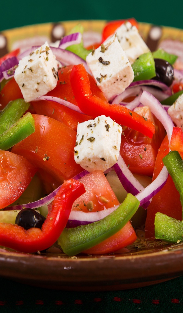Аппетитный греческий салат в тарелке на столе