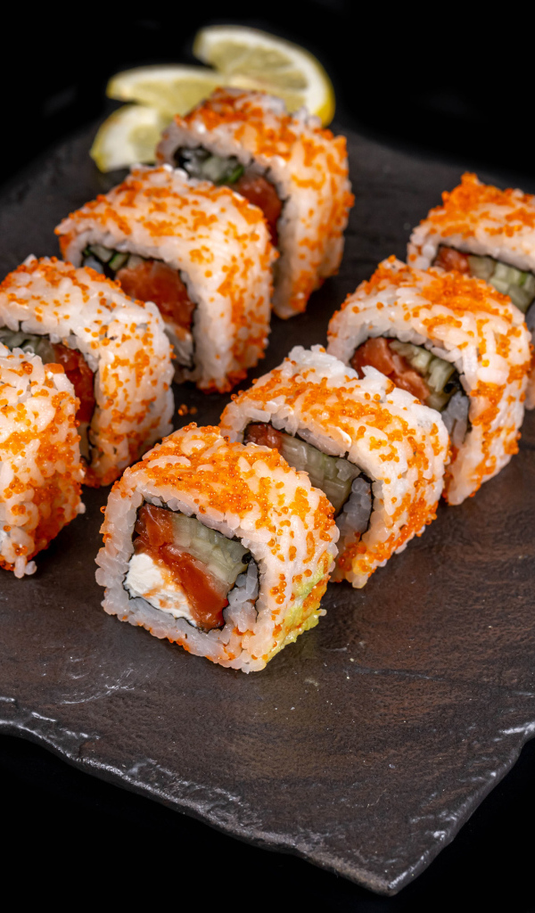 Аппетитные японские роллы с соусом васаби на черном фоне