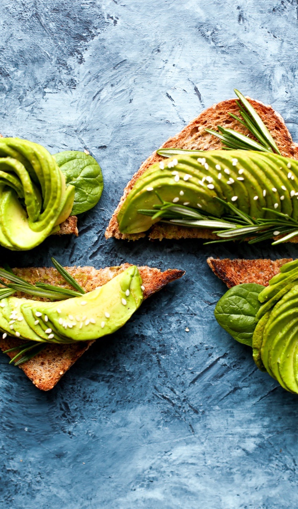 Bread with avocado and basil on the table