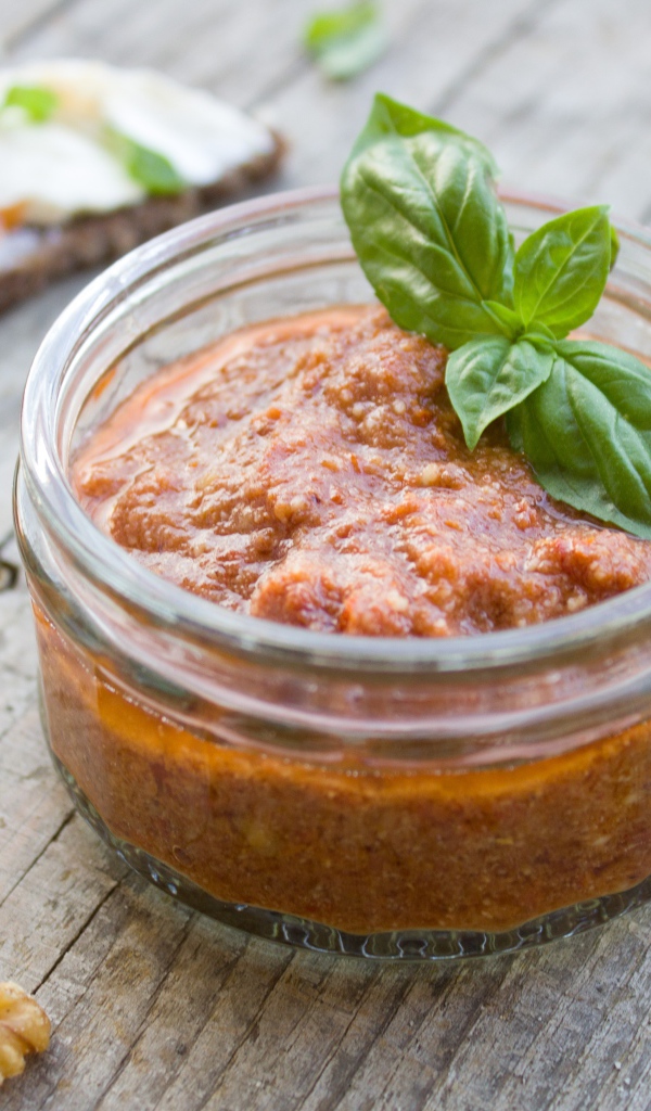 Икра в банке с базиликом на столе с орехами 