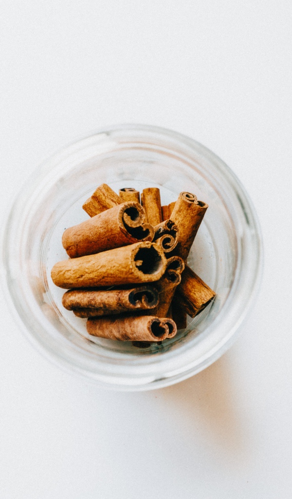 Корица в стеклянной банке на белом фоне 