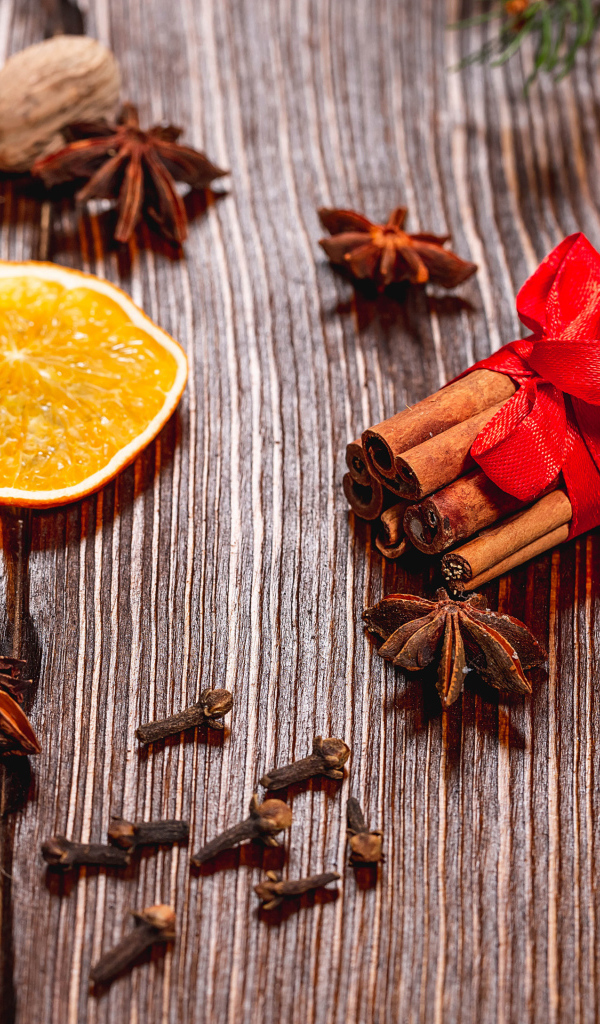 Корица на столе с орехами, бадьяном, сушеными апельсинами и гвоздикой