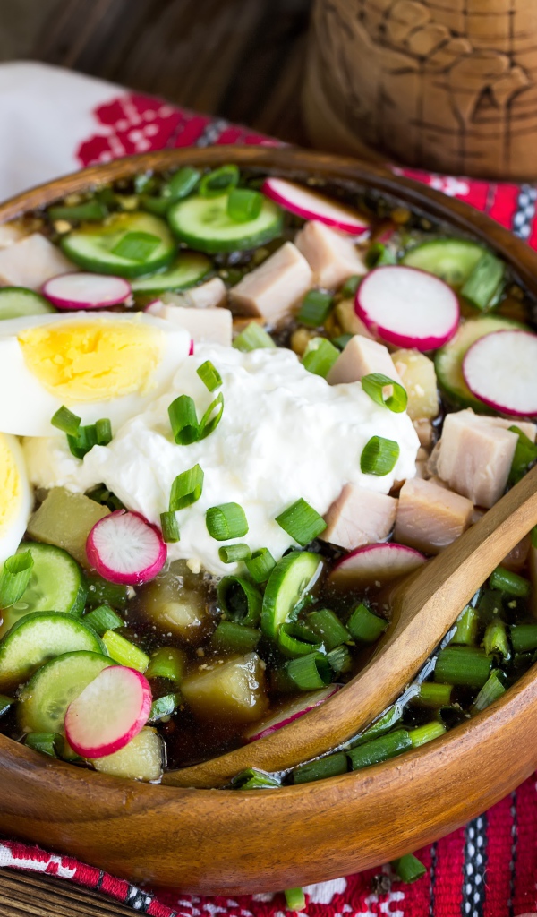 Холодная окрошка в деревянной миске на столе 