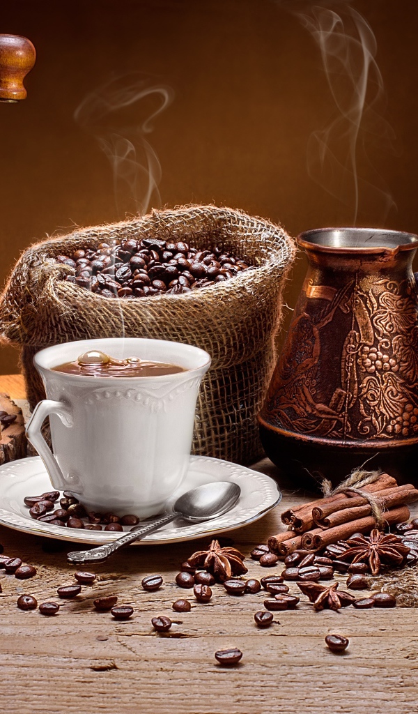 Чашка кофе на столе с круассанами и кофемолкой