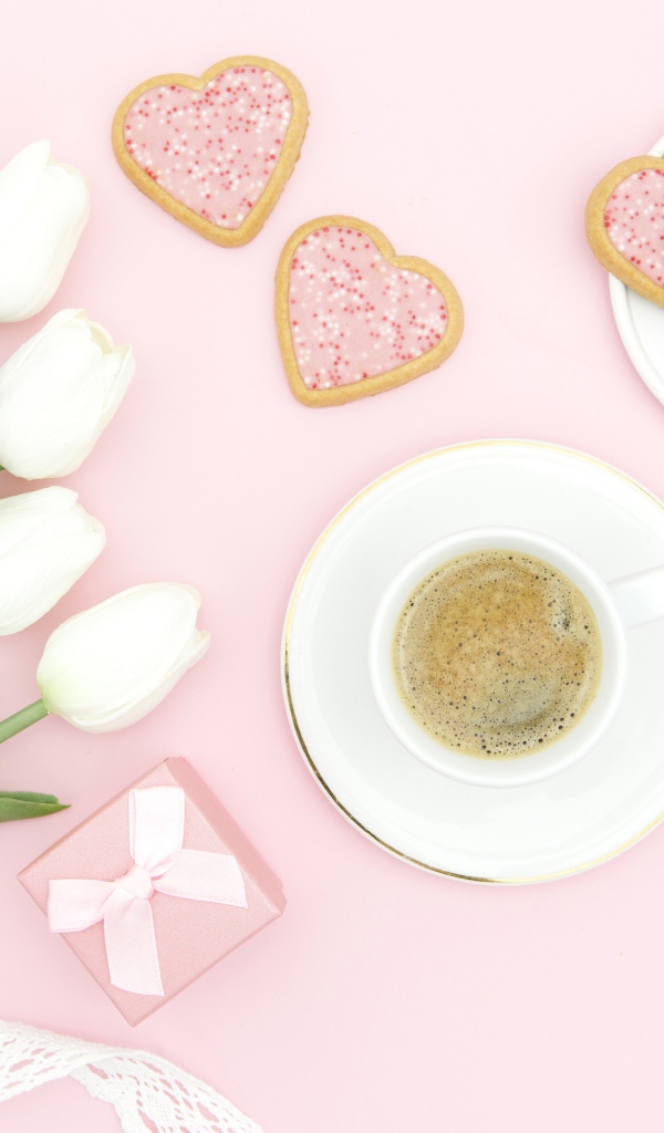 Чашка кофе с печеньем на столе с букетом белых тюльпанов