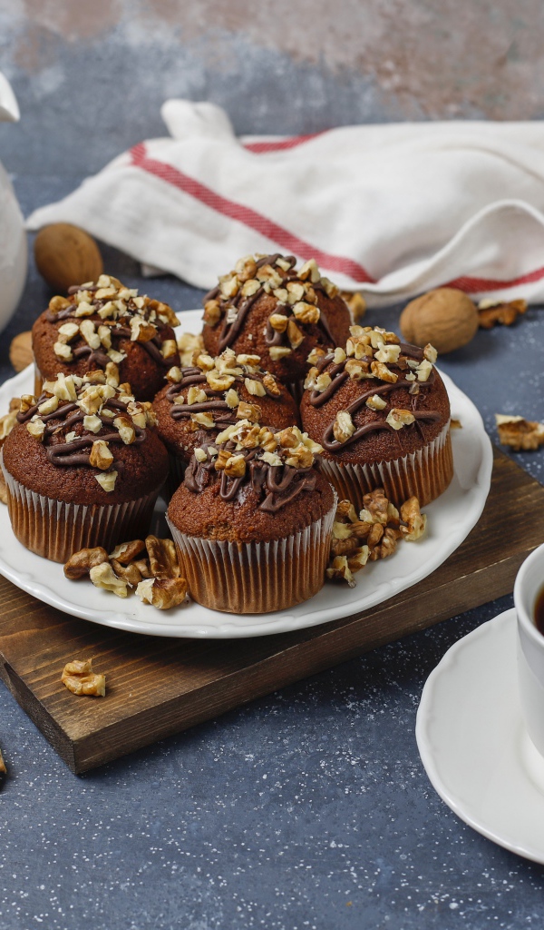 Вкусные шоколадные кексы с орехами на столе с кофе