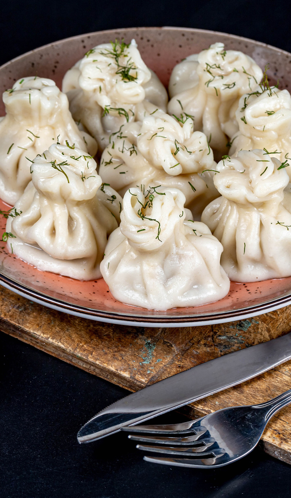 Вкусные горячие хинкали на столе с соусом