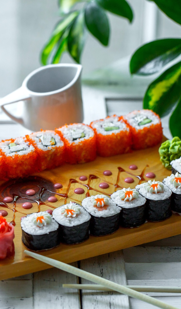 Вкусные суши и роллы на столе с имбирем