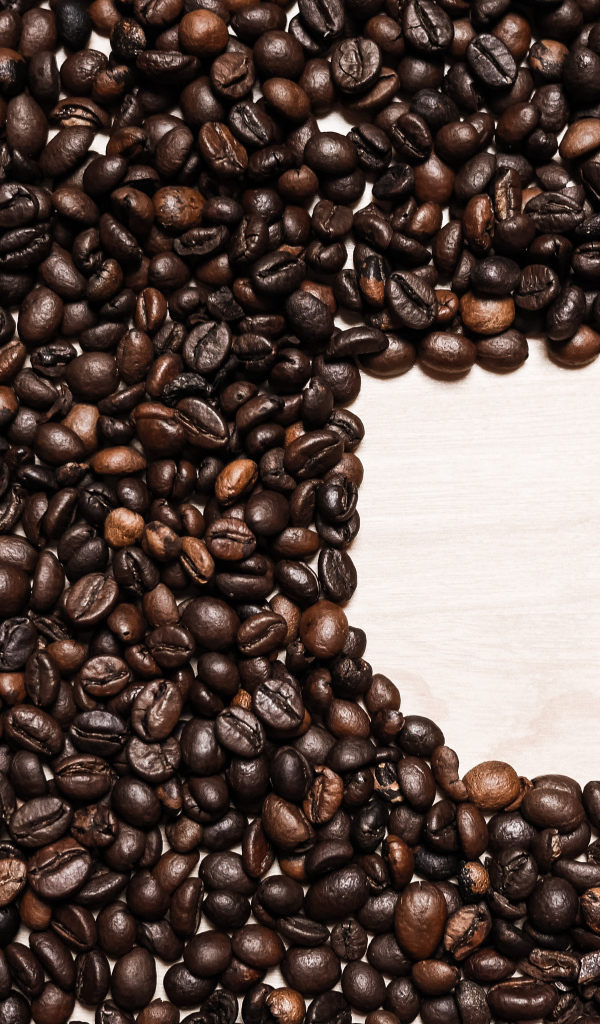 Рисунок чашки из кофейных зерен на столе