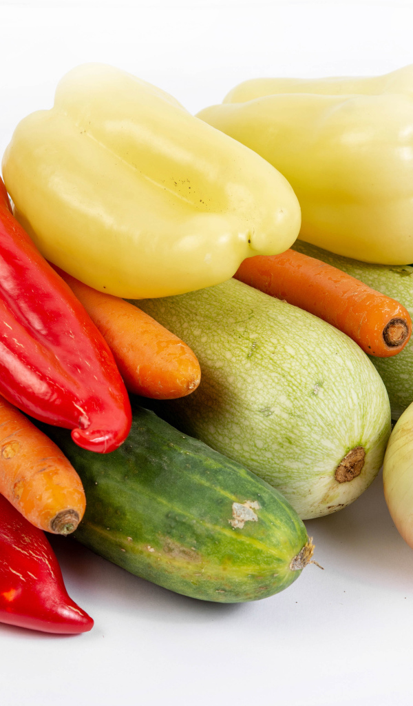 Свежие кабачки, огурцы, морковь, перец и лук на белом фоне
