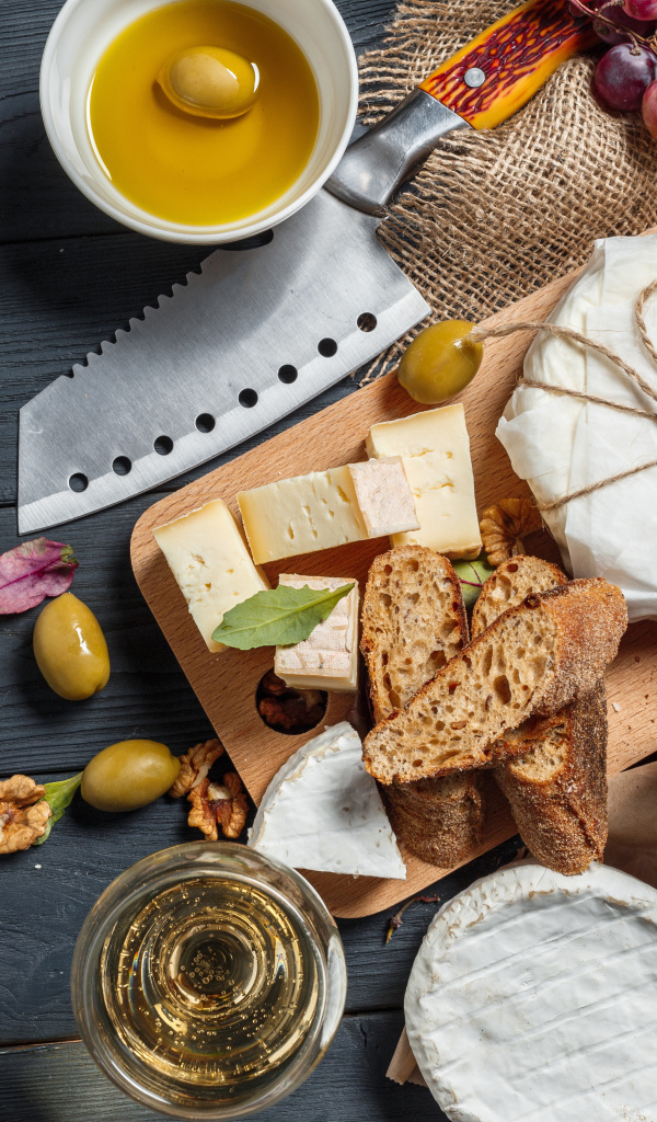 Виноград на столе с сыром, хлебом и оливками
