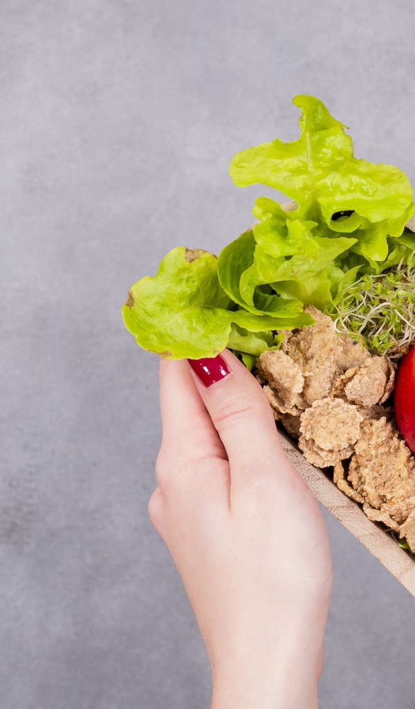 Коробка в форме сердца с яблоком и листьями салата 