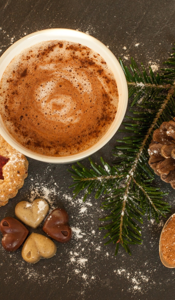 Горячий шоколад на столе веткой ели, печеньем и конфетами