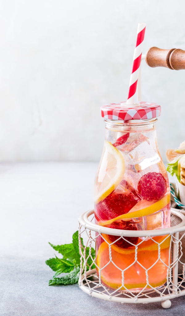 Банка с лимонадом в маленькой корзине с сэндвичем 