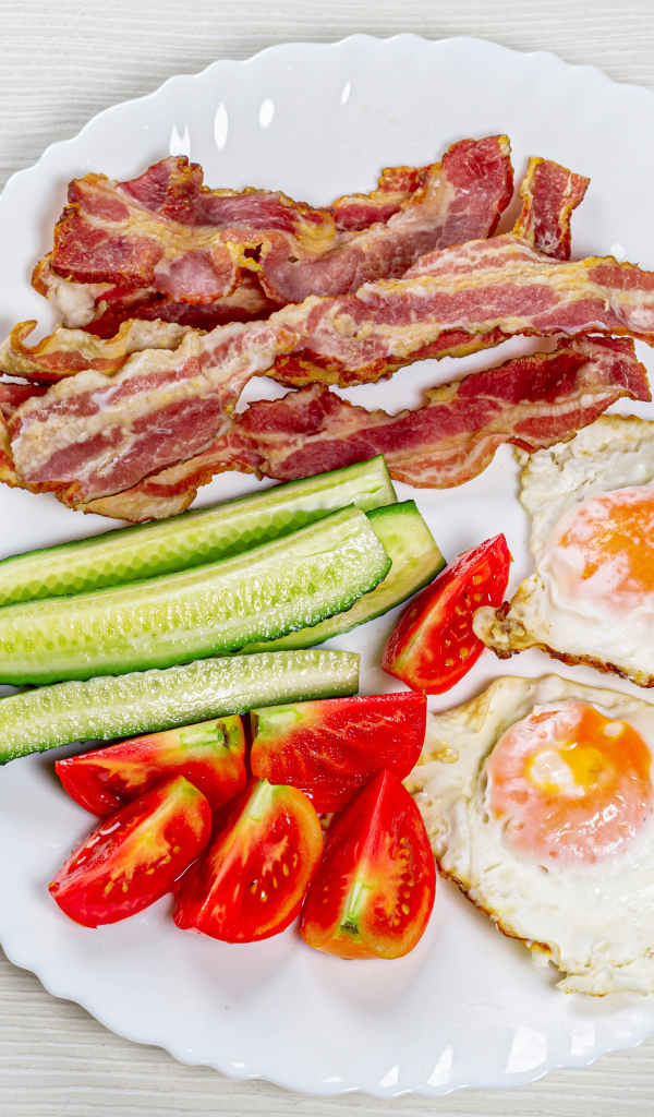 Большая белая тарелка с беконом, огурцами, помидорами и яичницей 