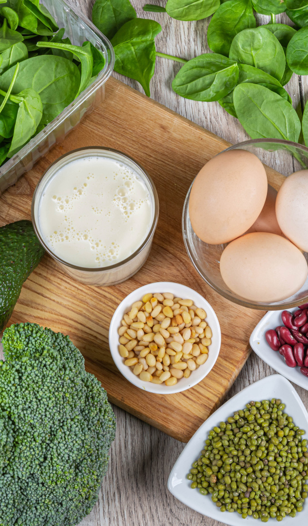 Бобовые, авокадо, базилик, яйца молоко и брокколи на столе