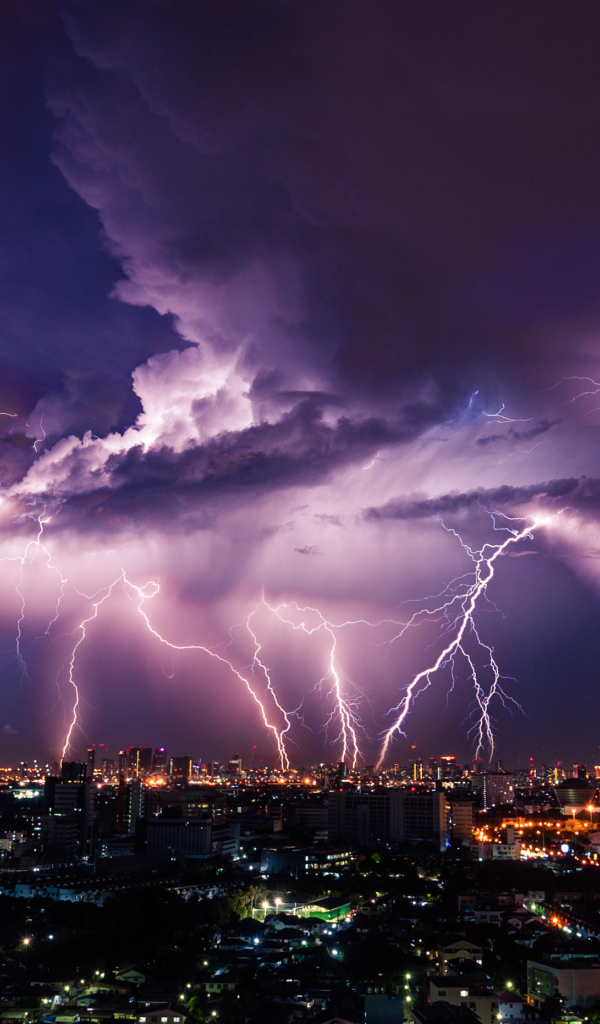 Молния пронзает грозовое небо над ночным городом