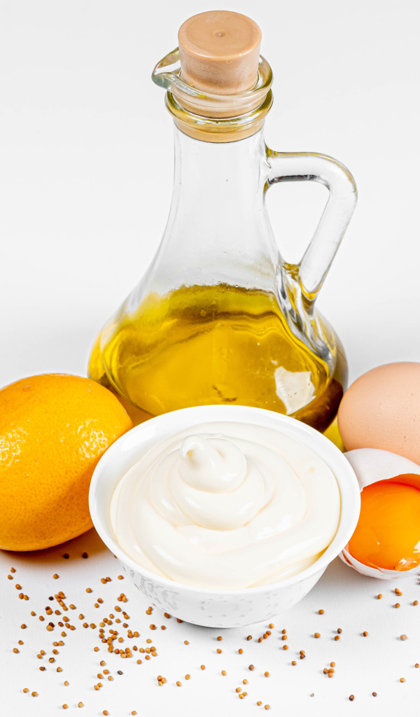 Оливковое масло, яйца и лимон на белом фоне с майонезом