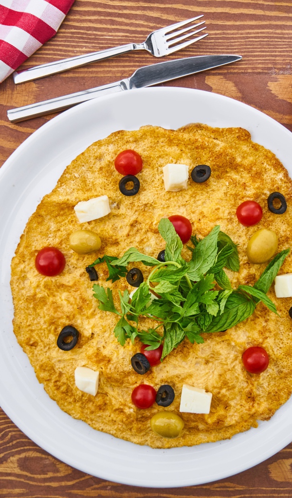 Омлет на столе с чаем, помидорами, яйцами и хлебом