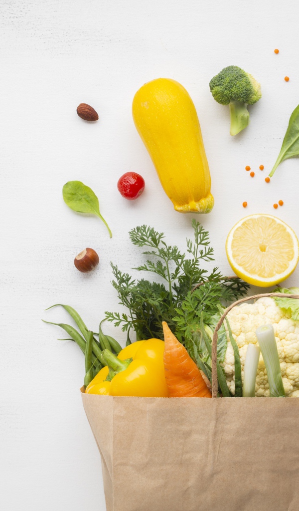 Пакет со свежими овощами и зеленью на сером фоне 