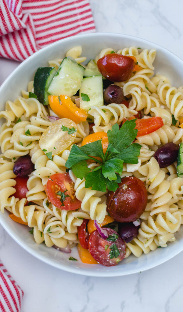 Макароны в тарелке с овощами на столе 