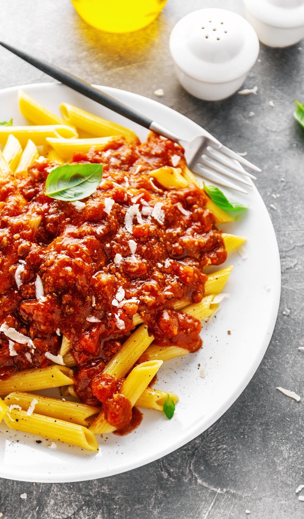 Макароны с соусом на белой тарелке