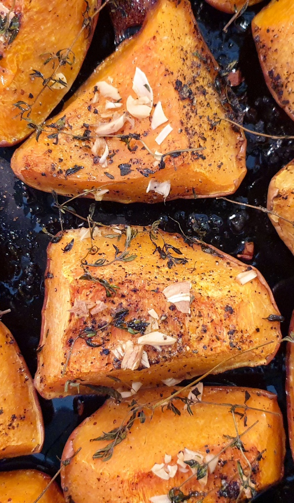 Куски жареной тыквы со специями на сковороде 