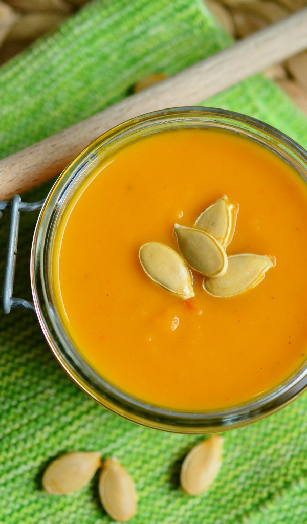 Тыквенный суп в стеклянной банке на столе 
