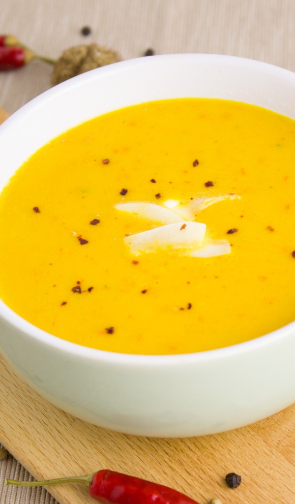 Тыквенный суп пюре на доске в белой тарелке 