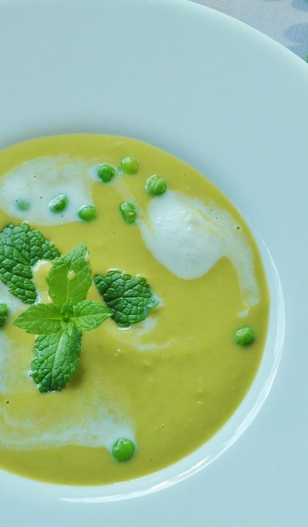 Puree soup with green peas in a white plate