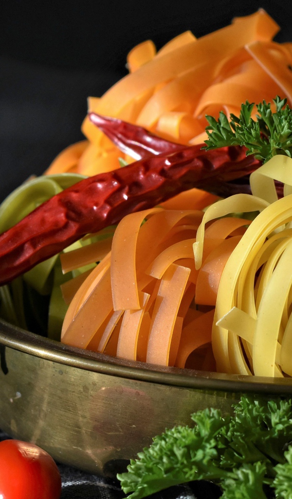 Сырая лапша на столе с острым перцем и петрушкой