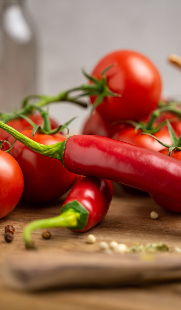 Красный острый перец с помидорами на столе