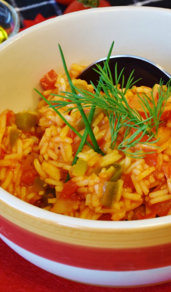 Рис с овощами в тарелке на столе