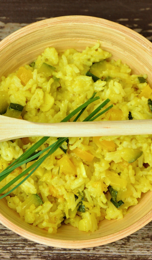 Блюдо ризотто в деревянной миске с ложкой