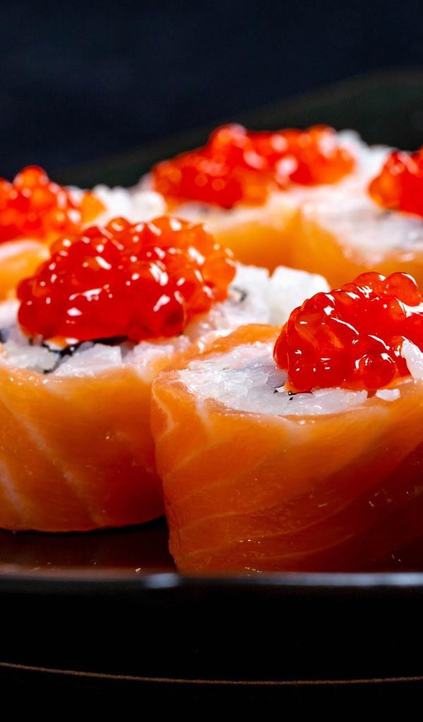 Роллы с красной рыбой и икрой на тарелке