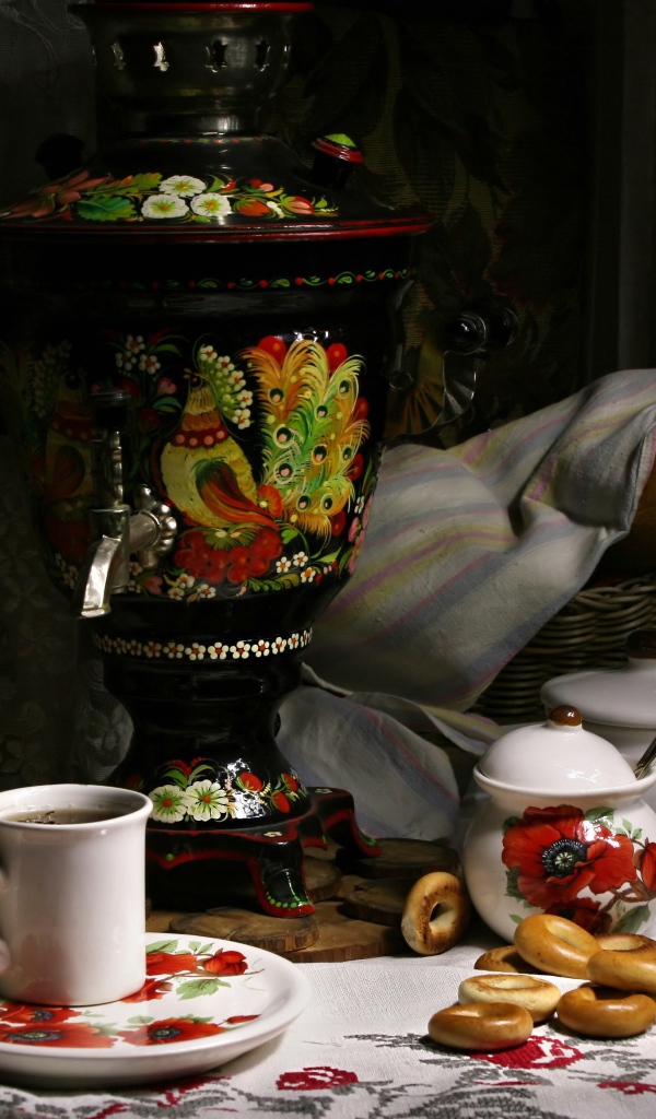 Самовар стоит на столе с чаем и баранками