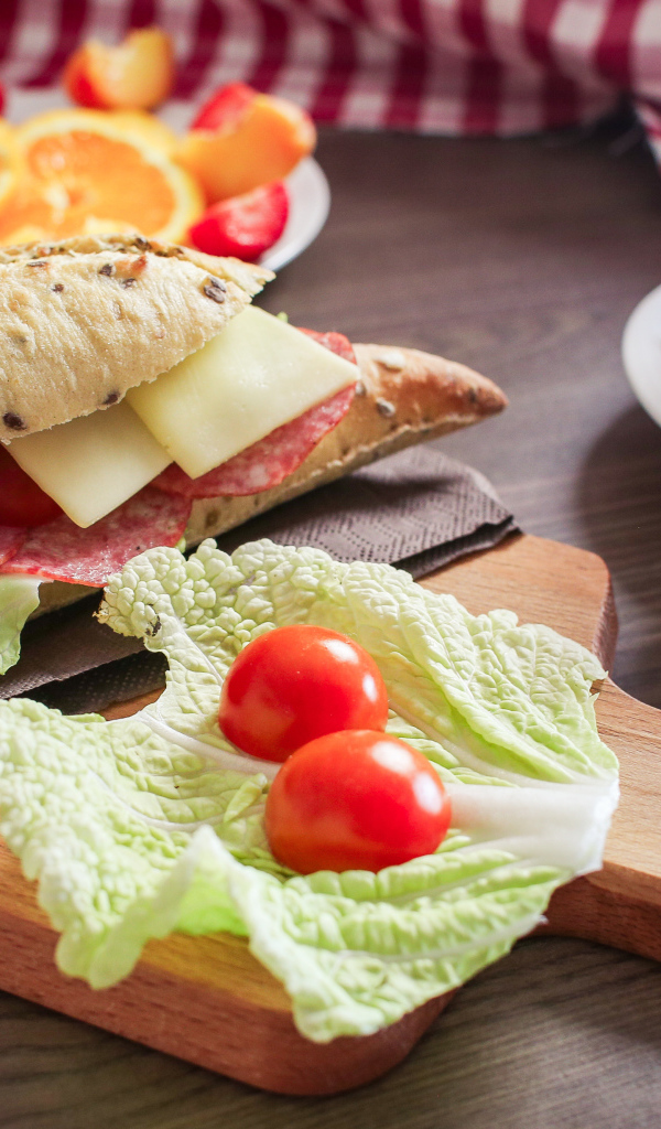 Бутерброды на столе с фруктами и чашкой чая