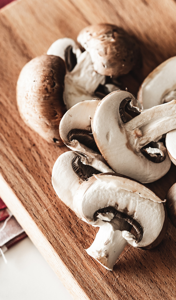 Нарезанные шампиньоны на разделочной доске