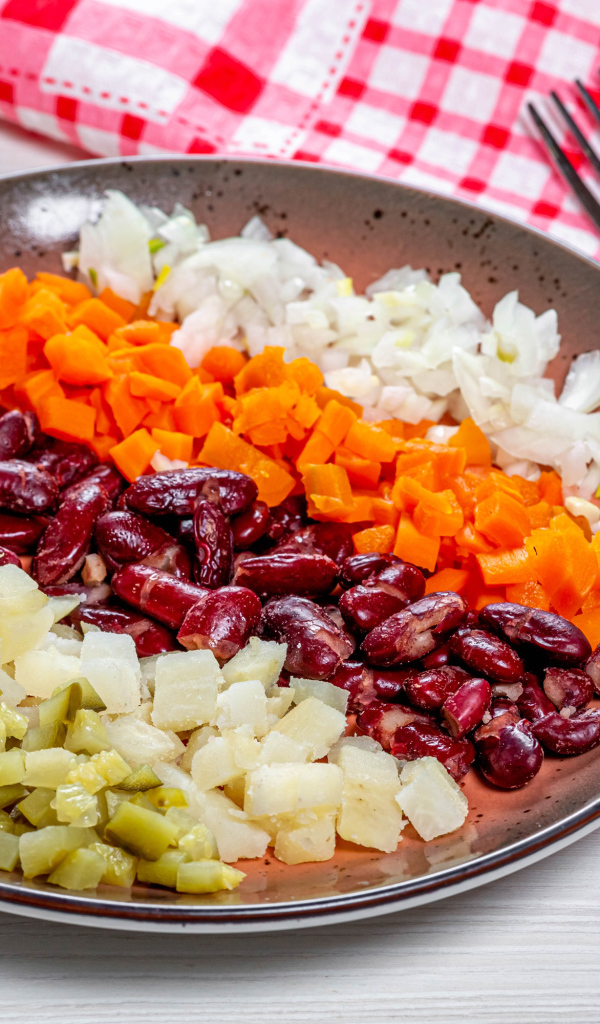 Овощи и фасоль нарезанные на тарелке 