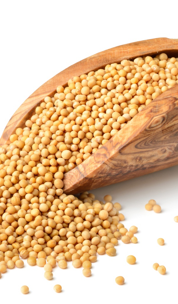 Мелкий горох в деревянном совке на белом фоне