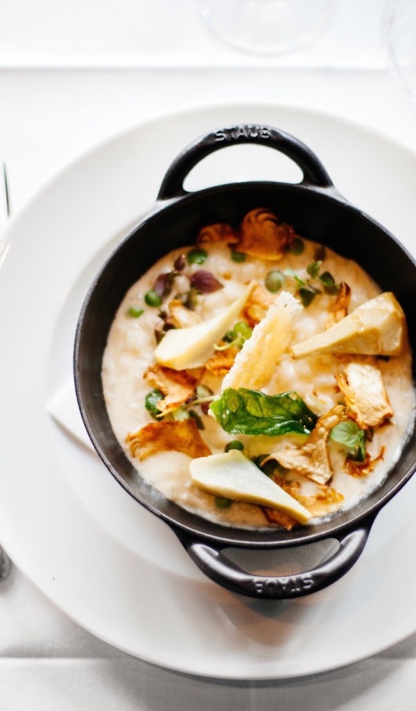 Суп в миске стоит на белой тарелке 