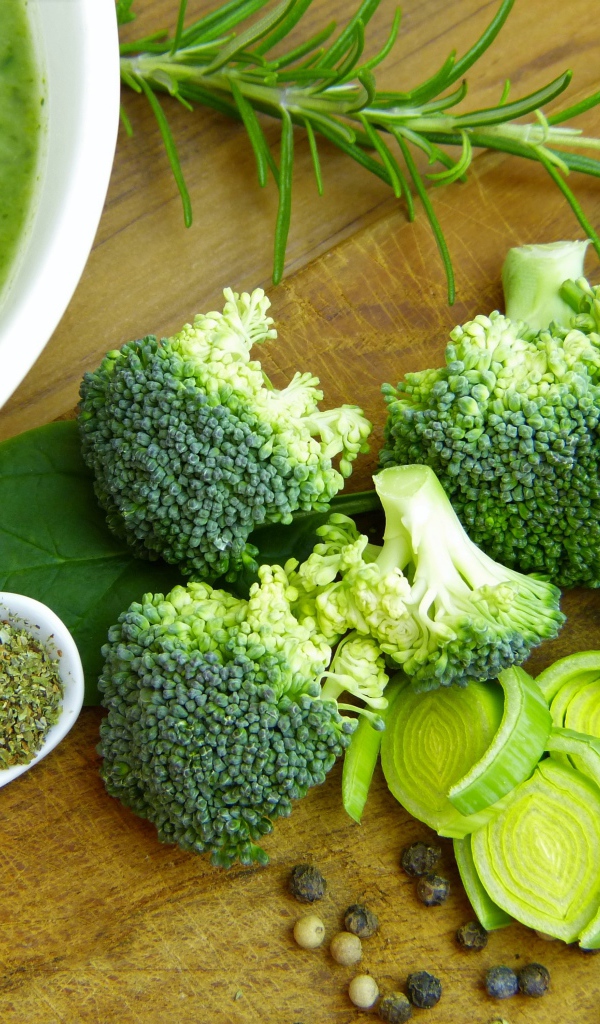 Суп пюре на столе с брокколи, зеленью и луком