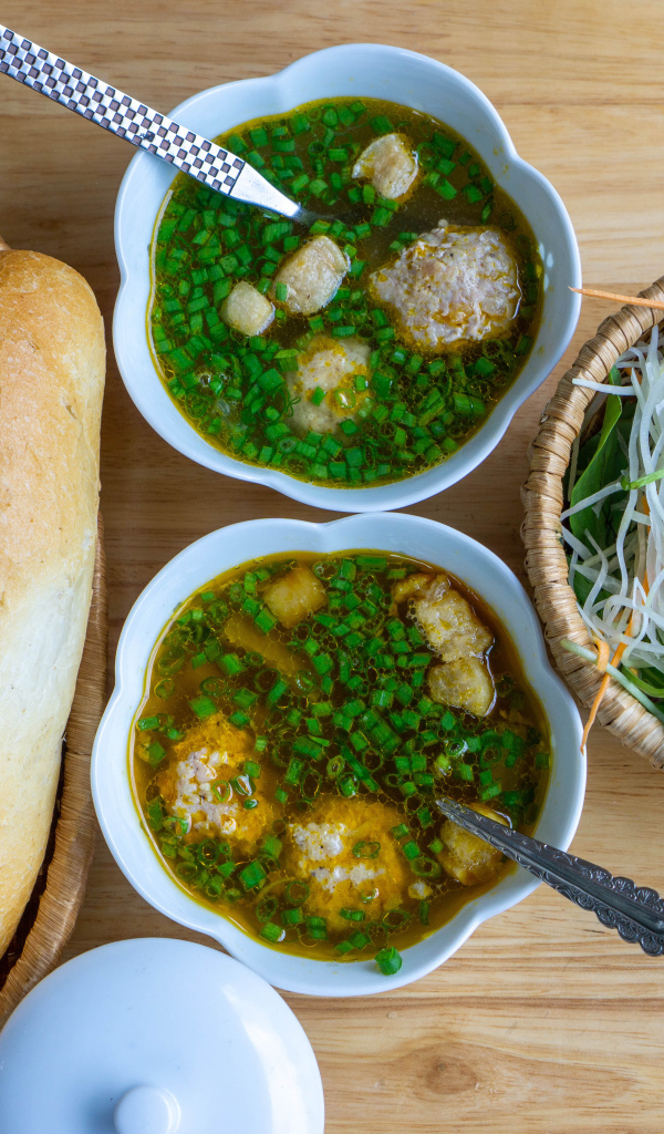 Суп с фрикадельками на столе с хлебом и салатом 