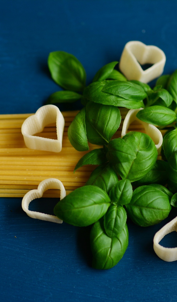 Спагетти с базиликом на синем фоне