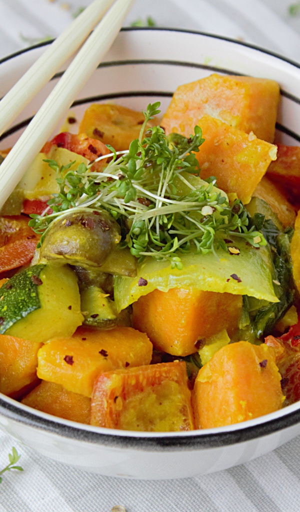 Острое блюдо из овощей в миске с палочками