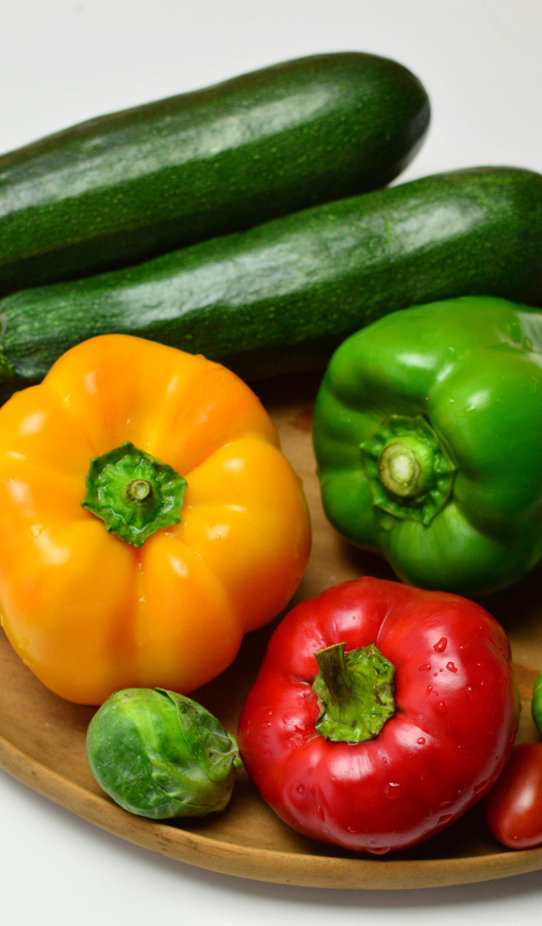Сладкий перец, кабачки, помидоры и брюссельская капуста на сером фоне