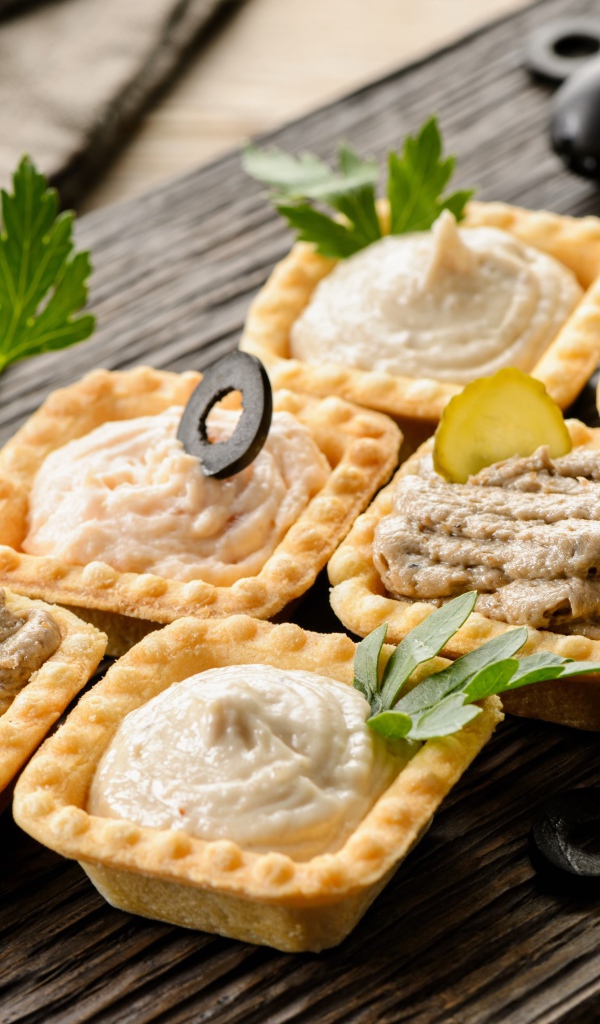 Тарталетки с паштетом на столе с оливками 