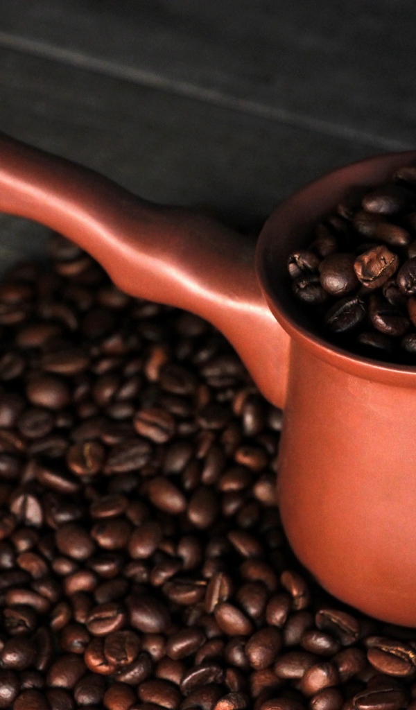 Турка с кофейными зернами на столе 